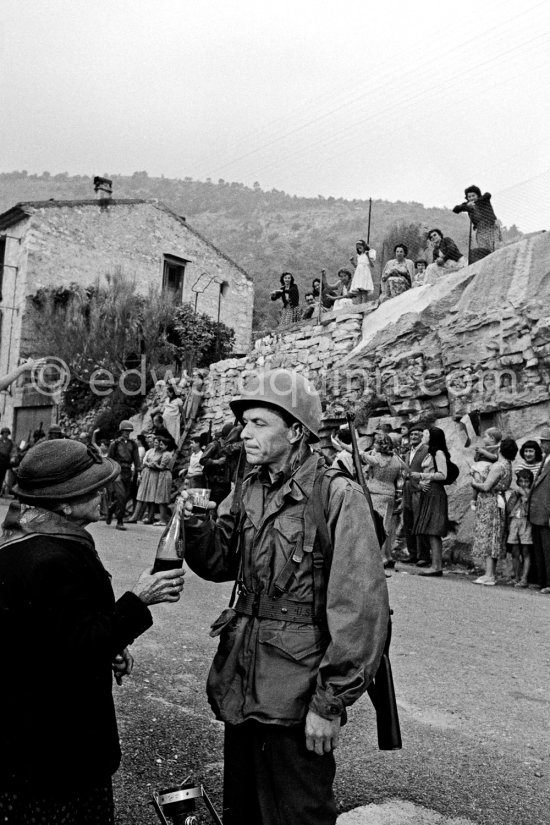 Frank Sinatra on the set of the film Kings Go Forth in the village of Tourette-sur-Loup, 1957. Sinatra needed an old lady to partner him in this scene. The villager Marie Isnard, who had never been to the cinema in her life, learned her lines and got through the dialogue very successfully. Sinatra's lines were: 'Vive General de Gaulle, Vive les Folies-Bergere", about the only French he knew. Tourrettes-sur-Loup 1957. - Photo by Edward Quinn