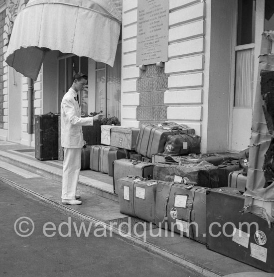 A valet counts Queen Soraya\'s luggage before departure to the airport. Hotrel Carlton, Cannes 1953. - Photo by Edward Quinn