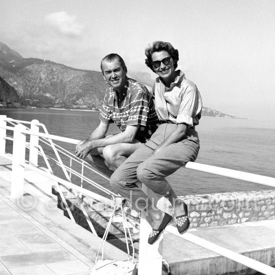 James Stewart and his wife Gloria on the rail of the swimming pool at the Hotel La Réserve, Beaulieu-sur-Mer 1954. - Photo by Edward Quinn