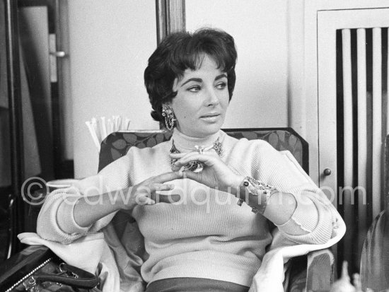 Attended by Cartier jewellers Liz Taylor tries on a beautiful diamond necklace with matching earrings she spotted while window-shopping in Monte Carlo with her third husband Mike Todd. At $500,000, the necklace was beyond Todd’s budget, but the earrings were her consolation prize. Monte Carlo 1958. - Photo by Edward Quinn