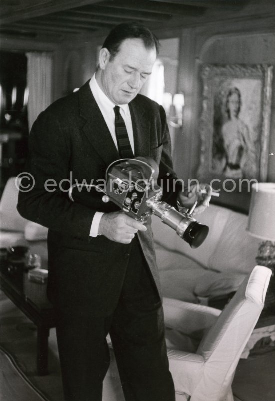 John Wayne checking out a Pathé film camera on board Onassis' yacht Christina, Monaco harbor 1955. - Photo by Edward Quinn