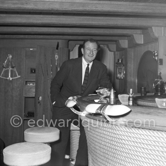 John Wayne on board Onassis' yacht Christina. Monaco harbor 1955. - Photo by Edward Quinn