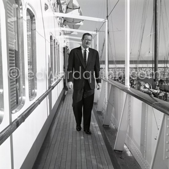 John Wayne on board Onassis' yacht Christina. Monaco harbor 1955. - Photo by Edward Quinn