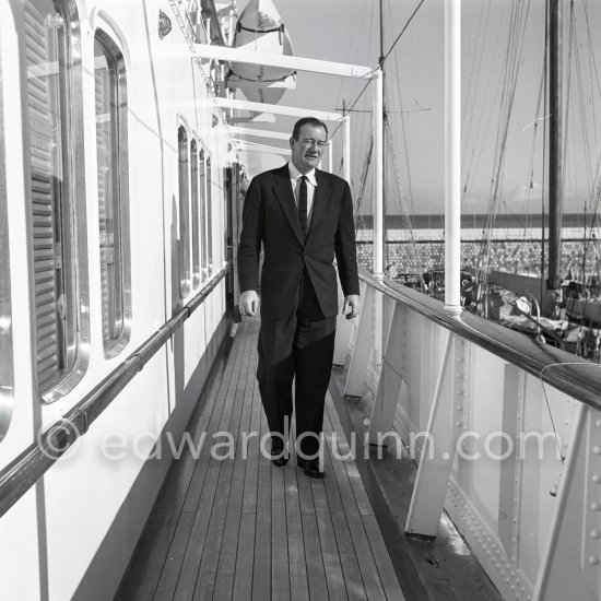 John Wayne on board Onassis' yacht Christina. Monaco harbor 1955. - Photo by Edward Quinn