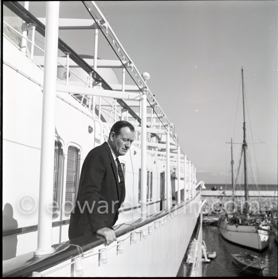 John Wayne on board Onassis' yacht Christina. Monaco harbor 1955. - Photo by Edward Quinn