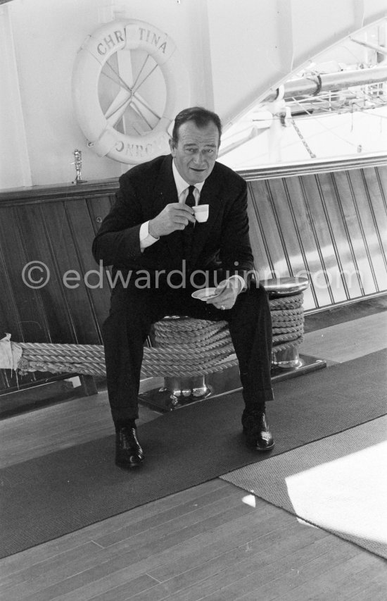 John Wayne on board Onassis' yacht Christina. Monaco harbor 1955. - Photo by Edward Quinn