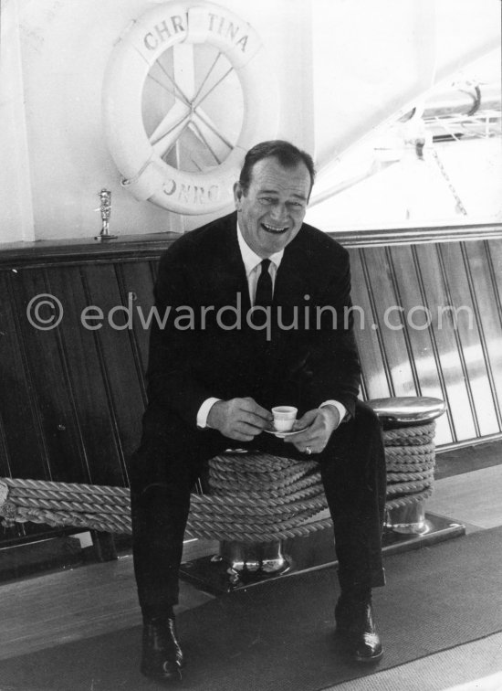 John Wayne on board Onassis' yacht Christina. Monaco harbor 1955. - Photo by Edward Quinn