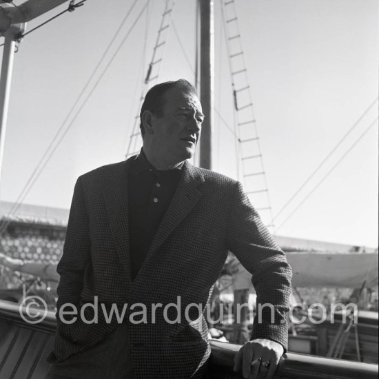 John Wayne on board Onassis' yacht Christina. Monaco harbor 1955. - Photo by Edward Quinn