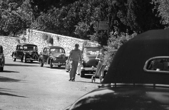 Jimmy Donahue, an heir to the Woolworth estate, and Wallis Simpson, Duchess of Windsor with the Windsor’s Pug. Although openly gay, Donahue claimed he had a four-year affair with the Duchess. Cannes 1953. Cars: Citroën Traction Avant, Peugeot, Cadillac - Photo by Edward Quinn