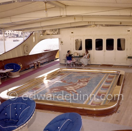 Tina Onassis and a not yet identified lady. The mosaic swimming pool which drained and rose to deck level to create a dance floor on board Onassis' yacht Christina. Monaco harbor 1955. - Photo by Edward Quinn