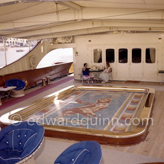 Tina Onassis and a not yet identified lady. The mosaic swimming pool which drained and rose to deck level to create a dance floor on board Onassis\' yacht Christina. Monaco harbor 1955. - Photo by Edward Quinn