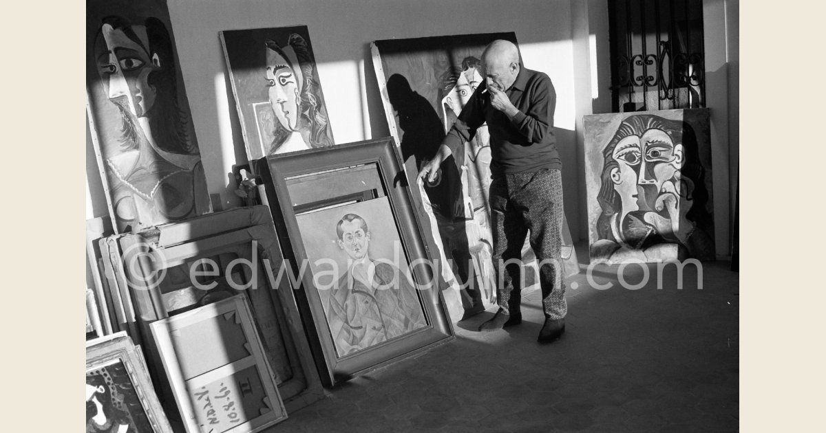 Pablo Picasso with his paintings and a work of his private