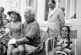Charlie Chaplin with two of his daughters, Josephine and Victoria (left). Chaplin was in Cannes to talk to the press about his latest film, "A King in New York", due to be premiered in London. When asked why he was wearing white gloves, he said it wasn't coquetry, but a slight case of eczema. Villa Lo Scoglietto, Saint-Jean-Cap-Ferrat, 1956. - Photo by Edward Quinn