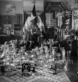 Louis Chiron at his museum of the victories: This photo on which are grouped the trophies of Chiron, summarizes thirty years of racing. One sees cups of Alfonso XIII., the Queen of England, the president of the Spanish Republic, Mussolini, the King of Italy, the Sultan of Morocco. The Count of Paris dedicated a photo "A Chiron the Centaur" to him. Monaco 1954. - Photo by Edward Quinn