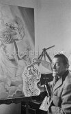 Salvador Dalí poses at his studio with his ink drawing of a madonna and her child and the painting "Cosmic Madonna", finished in 1958. At Salvador Dalí's house, Portlligat, Cadaqués, 1957. - Photo by Edward Quinn
