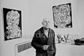 Jean Dubuffet with two of his paintings at his studio in Vence 1966. - Photo by Edward Quinn