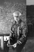 Max Ernst. Behind him the painting "Tremblement de terre printanier". Seillans 1966. - Photo by Edward Quinn