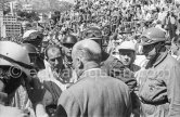 Driver's briefing by Antony Noghès. From left Maurice Trintignant, Peter Collins, Wolfgang von Trips, Stirling Moss, Jack Brabham, Mike Hawthorn, Stewart Lewis-Evans, Ivor Bueb. Monaco Grand Prix 1957. - Photo by Edward Quinn