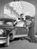 Rock Hudson at the entrance of Carlton Hotel. The concierge making sure he is in the picture. Cannes 1954. Car: 1953 Kaiser Manhattan - Photo by Edward Quinn