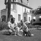 Prince Sadruddin ("Sadri") Aga Khan and his mother Princess Andrée, third wife of Aga Khan, at their home in Cap d’Antibes in 1954. with their attentive spaniel. - Photo by Edward Quinn