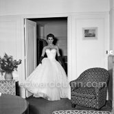 Sophia Loren in her Carlton Hotel room during the Cannes Film Festival wearing an evening gown designed by Emilio Schuberth, 27 April 1955. - Photo by Edward Quinn