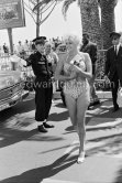An observant policeman. Curvy Jane Mansfield and her hardly recognizable Chihuahua. Cannes 1958. Car: Opel Kapitän 1956 or 1957. - Photo by Edward Quinn