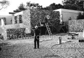 Joan Miró installing a sculpture in the gardens of Musée Maeght. Saint-Paul-de-Vence 1964. - Photo by Edward Quinn