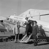 La Môme Moineau (the kid sparrow), "the richest woman of the Côte d'Azur", former flower seller, getting off her private plane Beech 18. On the right, her husband Mr. Benítez-Rexach, Dominican ship building millionaire. On the left: O'Dett, French cabaret entertainer.. Cannes Airport 1954. - Photo by Edward Quinn