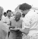 Pablo Picasso signing autographs on the occasion of the summer ceramics exhibition "Japon. Céramique contemporaine" at the Nérolium. Vallauris 21.7.1951. - Photo by Edward Quinn