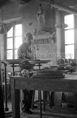 Pablo Picasso at work at the Madoura pottery in Vallauris. Above him is a statue of St-Claude, the patron saint of the potters, whose name was given to his younger son. Vallauris 23.3.1953. - Photo by Edward Quinn
