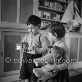 Claude Picasso and Paloma Picasso. Pablo Picasso showing a photo portrait of him when he was a seven years old child (detail of photo with his sister Lola in Malaga in 1888). La Galloise, Vallauris 1953. - Photo by Edward Quinn