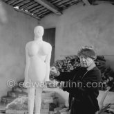 Pablo Picasso working on a plaster sculpture, La femme enceinte". In winter, Pablo Picasso wore warm clothes inside the studio, as heating was minimized to prevent the sculptures from. drying too quickly. In his studio Le Fournas, Vallauris 1953. - Photo by Edward Quinn