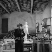 Pablo Picasso in his studio Le Fournas. In winter, Pablo Picasso wore warm clothes inside the studio, as heating was minimized to prevent the sculptures from drying too quickly. Vallauris 1953. - Photo by Edward Quinn