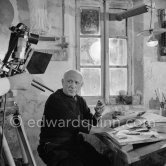 Pablo Picasso using a sharp instrument to scrape the surface of a clay plate as he designs a portrait. During filming of "Pablo Picasso", director Luciano Emmer, (left) and Pablo Picasso. Madoura pottery, Vallauris 14.10.1953. - Photo by Edward Quinn