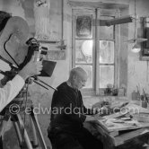 Pablo Picasso using a sharp instrument to scrape the surface of a clay plate as he designs a portrait. During filming of "Pablo Picasso", director Luciano Emmer, (left) and Pablo Picasso. Madoura pottery, Vallauris 14.10.1953. - Photo by Edward Quinn