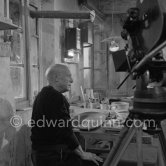 Pablo Picasso using a sharp instrument to scrape the surface of a clay plate as he designs a portrait. During filming of "Pablo Picasso", director Luciano Emmer, (left) and Pablo Picasso. Madoura pottery, Vallauris 14.10.1953. - Photo by Edward Quinn