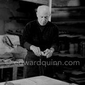 Pablo Picasso would sometimes squeeze a vase before the clay had hardened, molding it into a representational shape. "To give it life," he once said, "I have to wring its neck." Delighted that he could make the clay respond to any fantasy that passed through his mind, he shaped mythologicat figures such as fauns and satyrs, as well as vases representing graceful women, bulls, goats, fish, and above all, owls and doves. Here Pablo Picasso is working on small bird sculpture, Luciano Emmer film. Madoura pottery, Vallauris 14./15.10.1953. - Photo by Edward Quinn