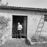 Pablo Picasso working in his sculpture studio Le Fournas making a sculpture figure with odds and ends from his scrap heap. Here he is collecting a branch to ad to the sculpture. The branch was later replaced by a key. The finished sculpture got the name "La femme à la clé (La Taulière)" ("Woman with a key"). Le Fournas, Vallauris 1953. - Photo by Edward Quinn