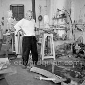 Pablo Picasso working in his sculpture studio Le Fournas making a sculpture figure with odds and ends from his scrap heap. Here he is adding a branch to the sculpture which was later replaced by a key. The finished sculpture got the name "La femme à la clé (La Taulière)" ("Woman with a key"). Le Fournas, Vallauris 1953. - Photo by Edward Quinn