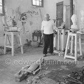 Pablo Picasso working in his sculpture studio Le Fournas making a sculpture figure with odds and ends from his scrap heap. Here he is adding a branch to the sculpture which was later replaced by a key. The finished sculpture got the name "La femme à la clé (La Taulière)" ("Woman with a key"). Le Fournas, Vallauris 1953. - Photo by Edward Quinn