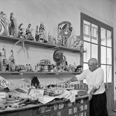 Pablo Picasso in front of a board with ceramics. Le Fournas, Vallauris 1953. - Photo by Edward Quinn