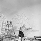 Pablo Picasso working on the "War and Peace study" drawings on the wall of Chapelle de la Paix (or Temple de la Paix) for the documentary film of Luciano Emmer. (The panels of War and Peace of 1952 were away on exhibition). Vallauris 1953. - Photo by Edward Quinn