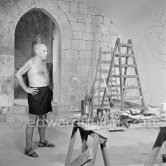 Picasso working on the "War and Peace study" drawings on the wall of Chapelle de la Paix (or Temple de la Paix) for the documentary film of Luciano Emmer. (The panels of War and Peace of 1952 were away on exhibition). Vallauris 1953. - Photo by Edward Quinn