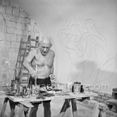 Pablo Picasso working on the "War and Peace study" drawings on the wall of Chapelle de la Paix (or Temple de la Paix) for the documentary film of Luciano Emmer. (The panels of War and Peace of 1952 were away on exhibition). Vallauris 1953. - Photo by Edward Quinn