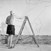 Pablo Picasso working on the "War and Peace study" drawings on the wall of Chapelle de la Paix (or Temple de la Paix) for the documentary film of Luciano Emmer. (The panels of War and Peace of 1952 were away on exhibition). Vallauris 1953. - Photo by Edward Quinn