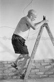 Pablo Picasso working on the "War and Peace study" drawings on the wall of Chapelle de la Paix (or Temple de la Paix) for the documentary film of Luciano Emmer. (The panels of War and Peace of 1952 were away on exhibition). Vallauris 1953. - Photo by Edward Quinn