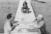 Pablo Picasso with an unknown person. Paloma Picasso in the background. Golfe-Juan 1954. - Photo by Edward Quinn