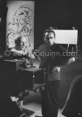 Pablo Picasso working on a bucolic pastoral scene on drawing paper which was to serve as background for the film "Le mystère Picasso". Nice, Studios de la Victorine 1955. - Photo by Edward Quinn