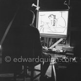 During filming of "Le mystère Picasso". Pablo Picasso working on "Nature morte". Pablo Picasso had a frame constructed on which he could stretch a transluscent piece of paper. He drew on one side, and the camera filmed the drawing being born from the other side. Nice, Studios de la Victorine 1955. - Photo by Edward Quinn
