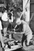Pablo Picasso preparing his painting utensils observed by participants of a studio tour. "Le mystère Picasso", Nice, Studios de la Victorine 1955. - Photo by Edward Quinn